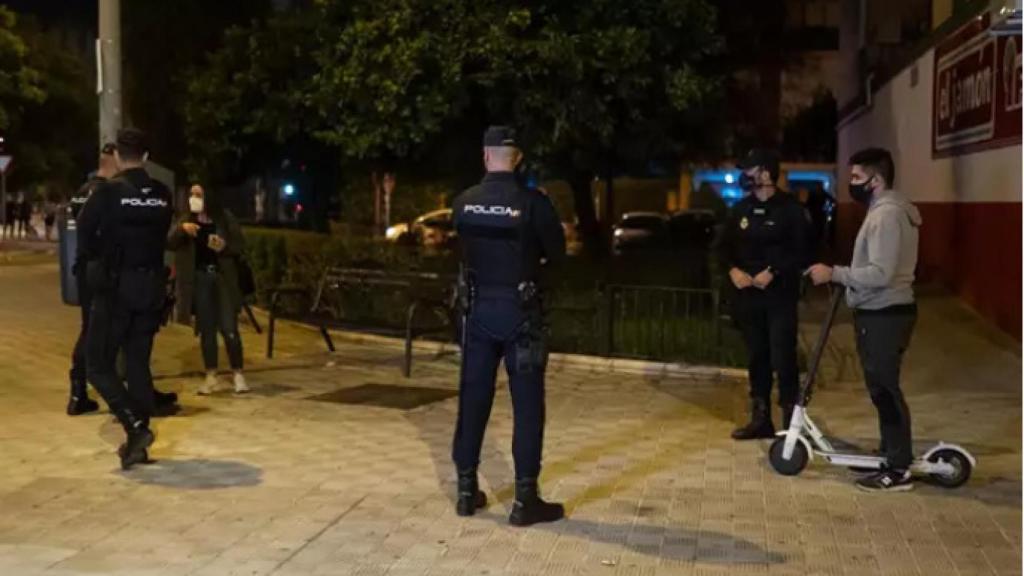 Agentes de la Policía Nacional, junto a un usuario de patinete eléctrico.