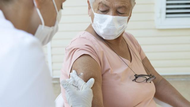 Un profesional sanitario poniendo una vacuna.