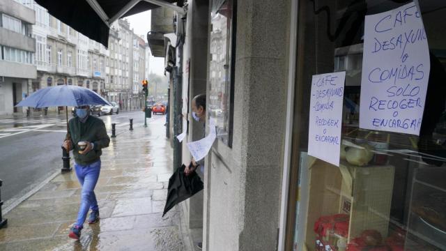 Un hombre pasa al lado de un establecimiento cerrado por el Covid en Santiago.