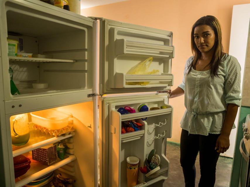 La venezolana Luznaily Sulbarán abre su nevera y apenas encuentra un pequeño trozo de queso para acompañar las tradicionales arepas que desayunará junto a sus dos hijas, menores de edad, una fría mañana en Los Teques, la capital del estado de Miranda, cercano a Caracas.