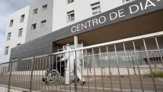 Un trabajador sanitario acude a buscar a un anciano de la residencia de ancianos de San Cibrao.