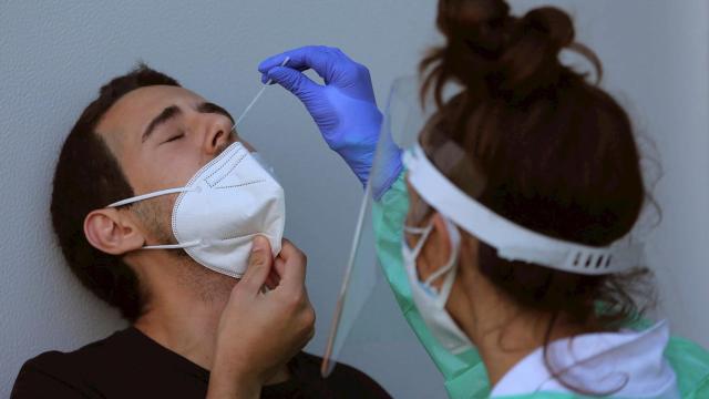 Personal sanitario realiza una prueba de PCR a un hombre.