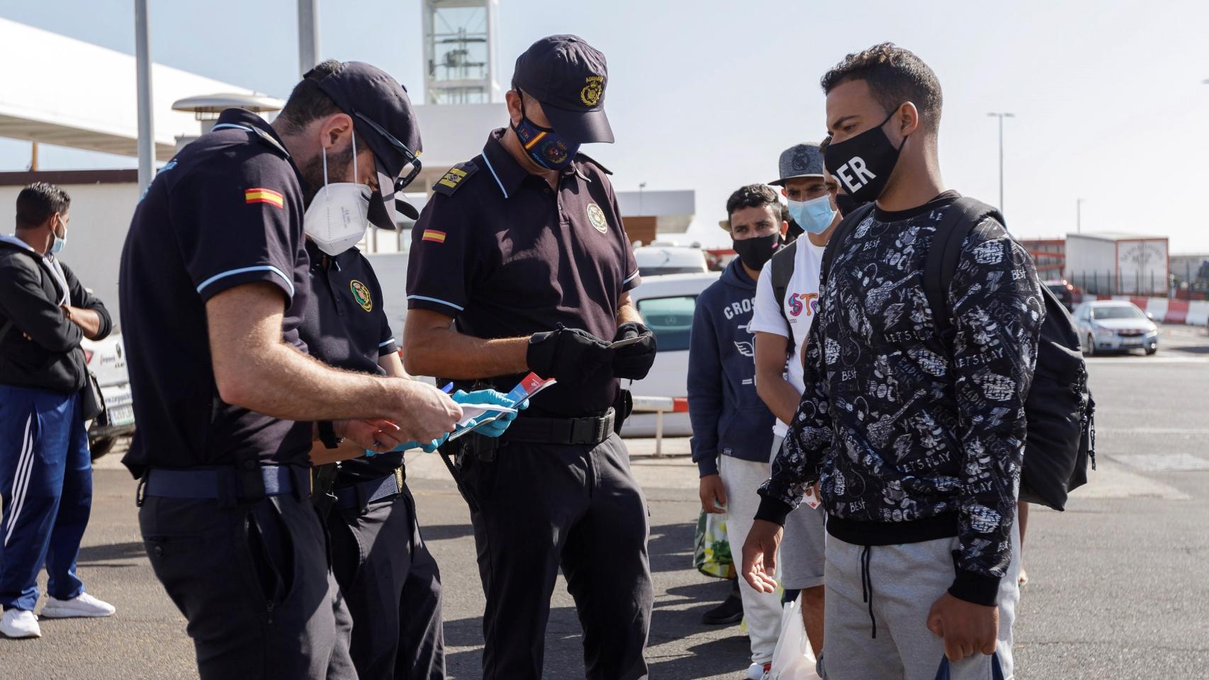 Agentes de Policía toman los datos a varios inmigrantes en Santa Cruz de Tenerife.