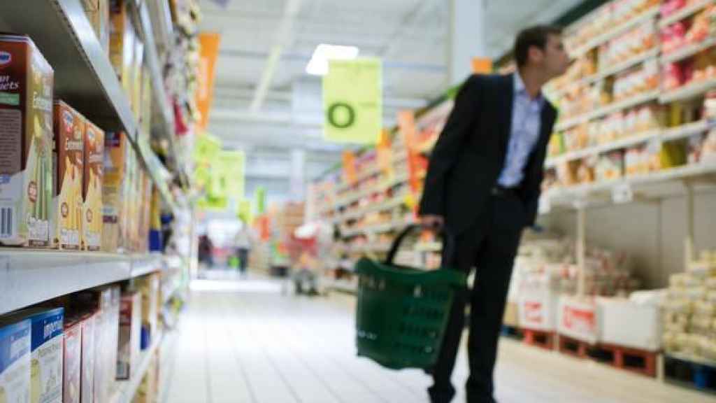 Un hombre mira las etiquetas en un supermercado.
