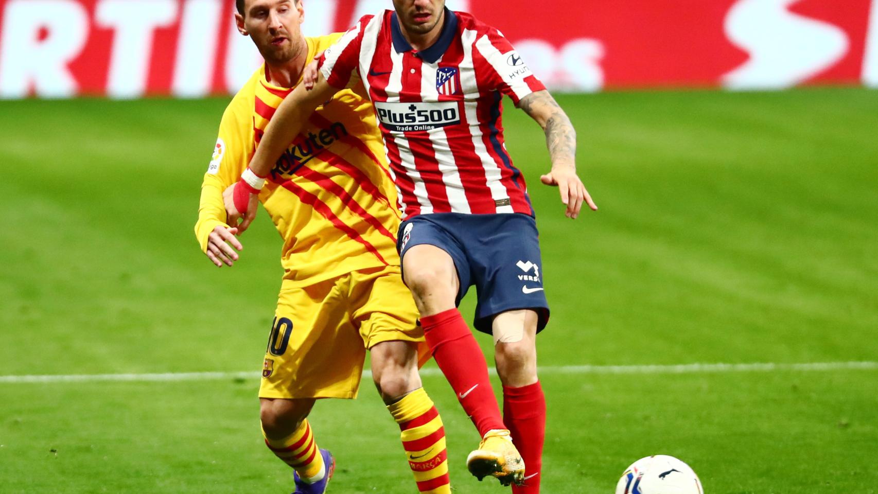 Saúl Ñíguez, perseguido por Leo Messi durante el Atlético de Madrid - Barcelona de La Liga