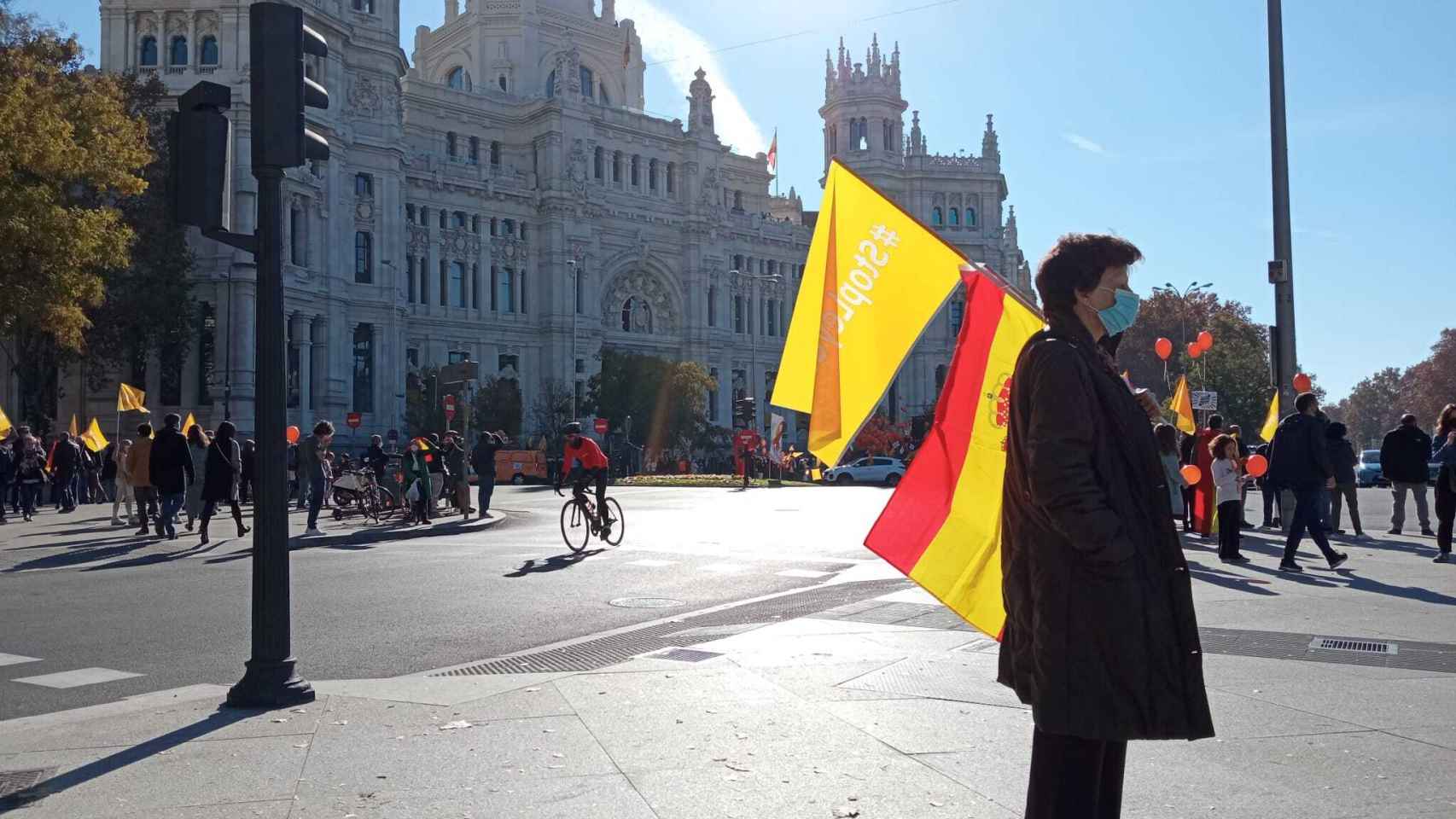 Una mujer ante el Ayuntamiento de Madrid, porta una bandera de España y una baderola contra la Ley Celaá.