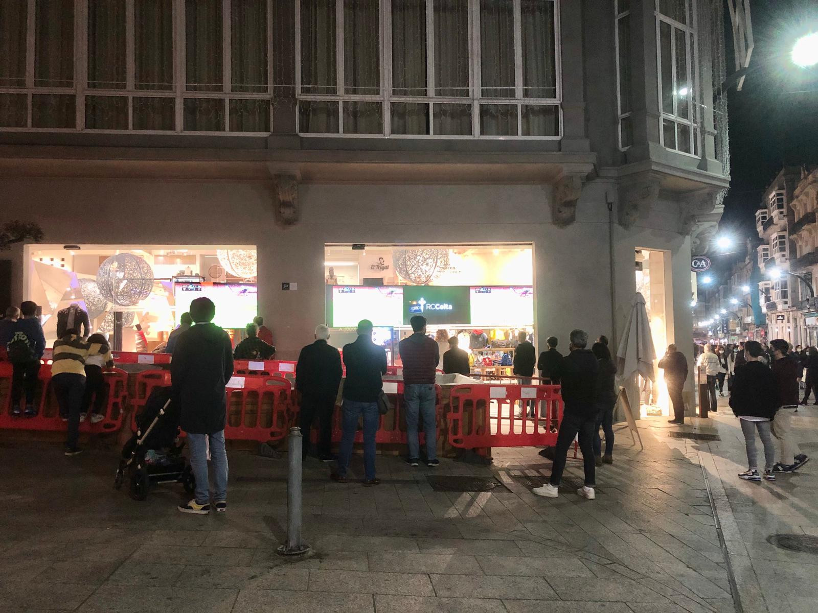 Viandantes de la Rúa Príncipe observan el Sevilla-Celta desde la calle. | Foto: Andrea Pérez-Bouzada