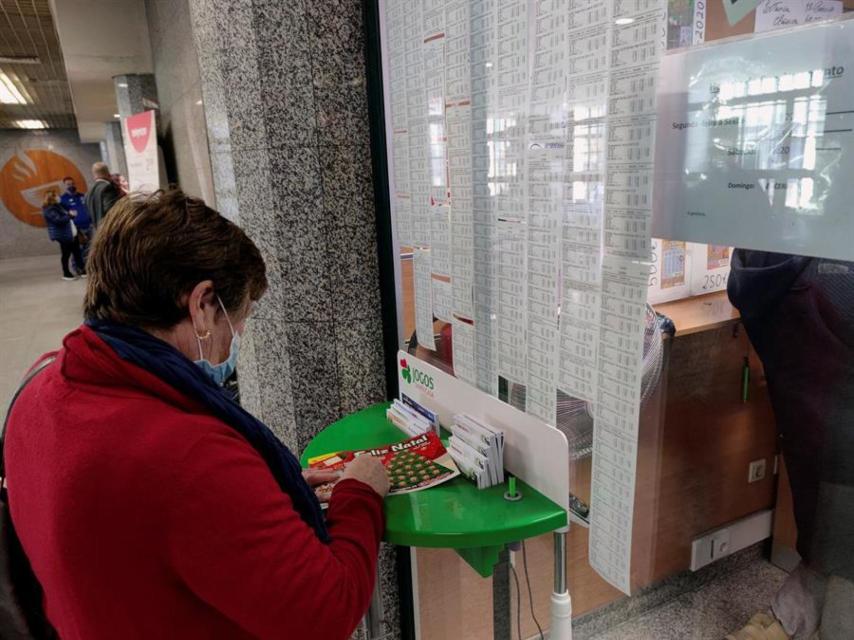 Una mujer jugando al 'rasca y gana'.