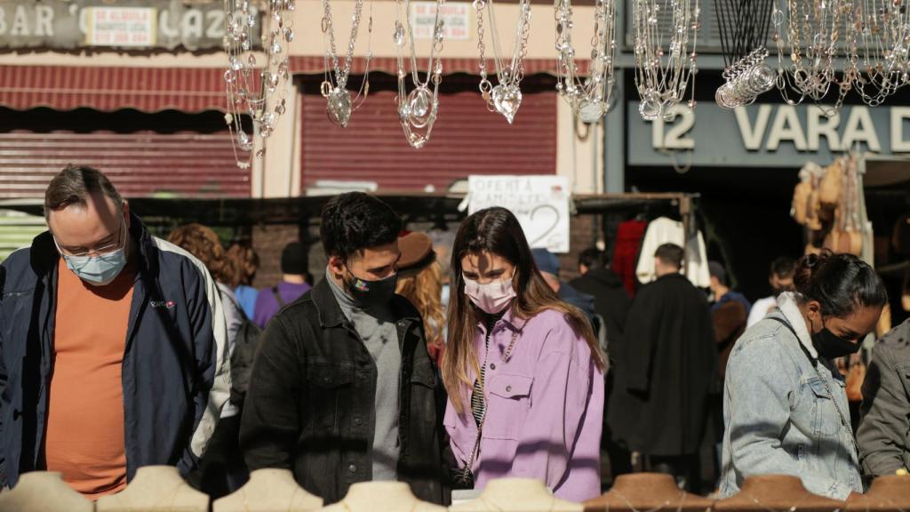 Personas pasean por el Rastro de Madrid.