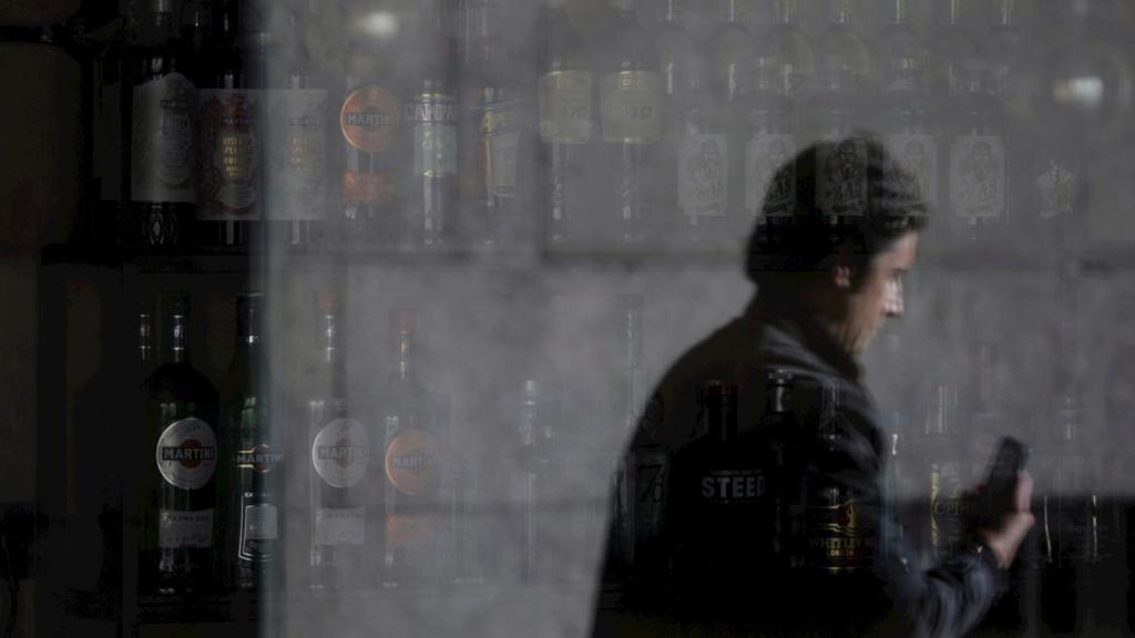 Un hombre reflejado en la ventana de un bar de La Coruña.