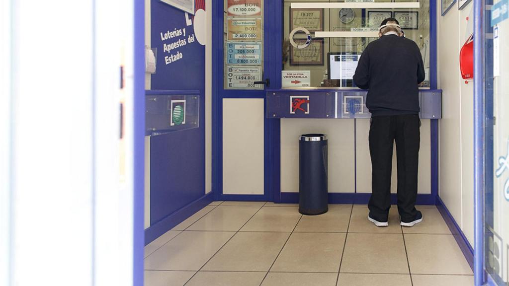 Un hombre compra lotería en una Administración.