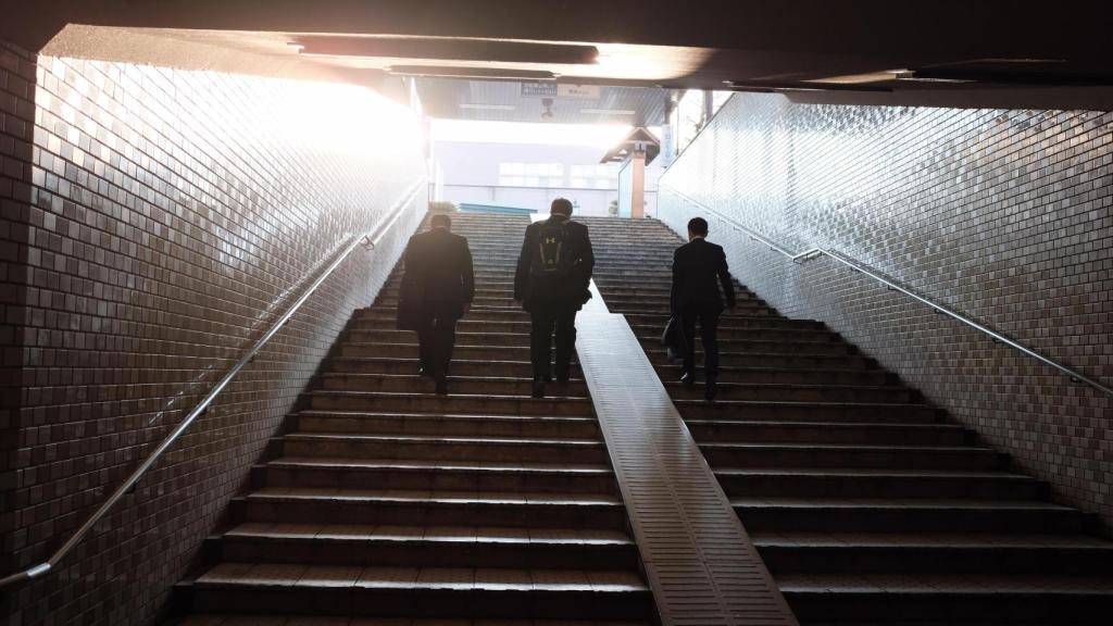 Tres ejecutivos subiendo unas escaleras.