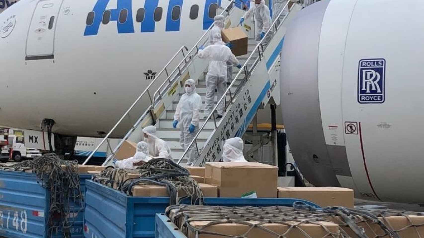 Operarios descargan material sanitario de un avión.