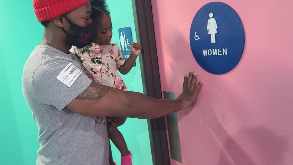 Muhammed Nitoto con su hija entrando en el baño de chicas.