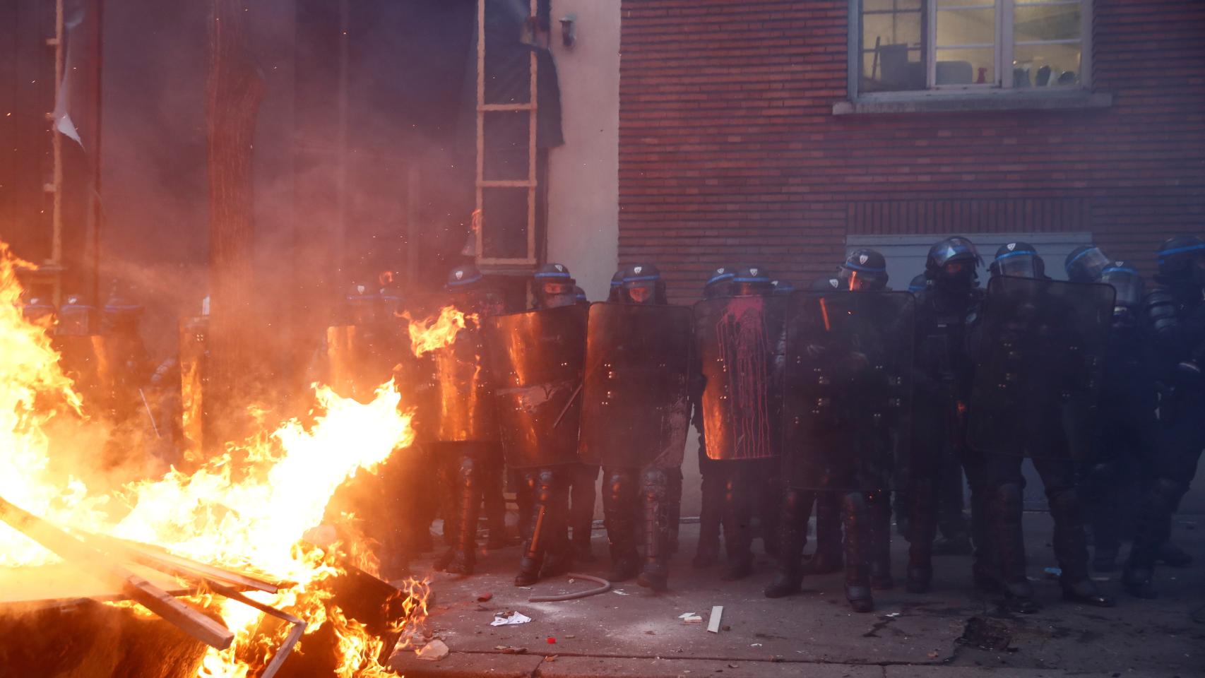 Antidisturbios de la policía francesa ante una barricada levantada por los manifestantes en París.