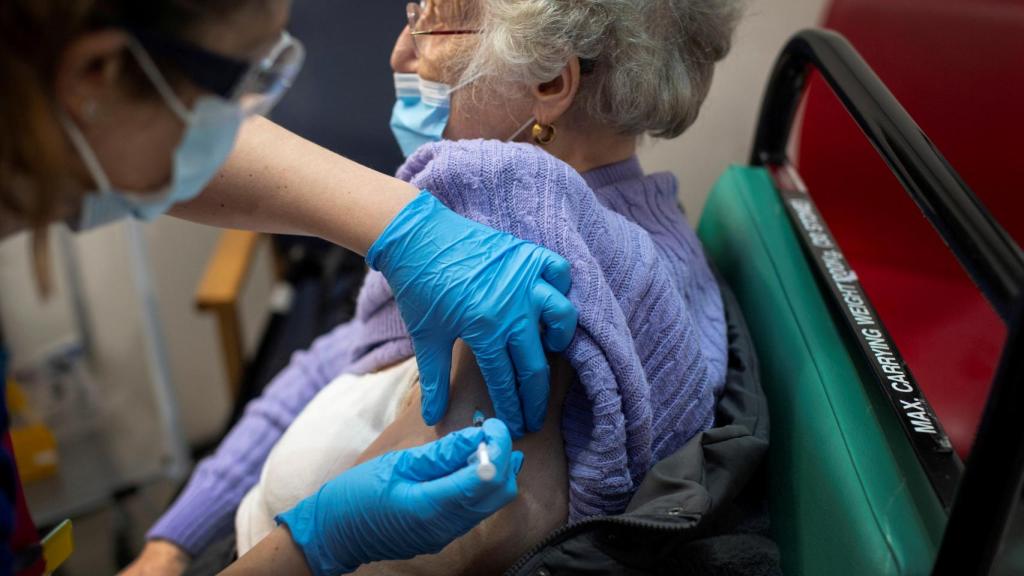 Una mujer se pone la vacuna de Pfizer.