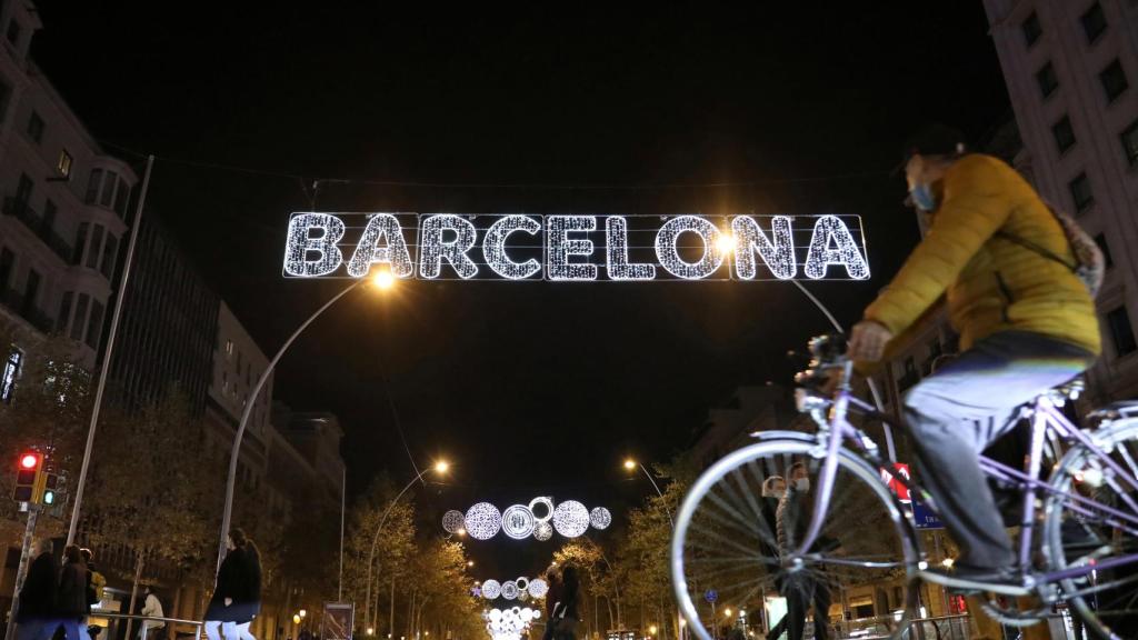 Paseantes debajo de las luces de Barcelona.