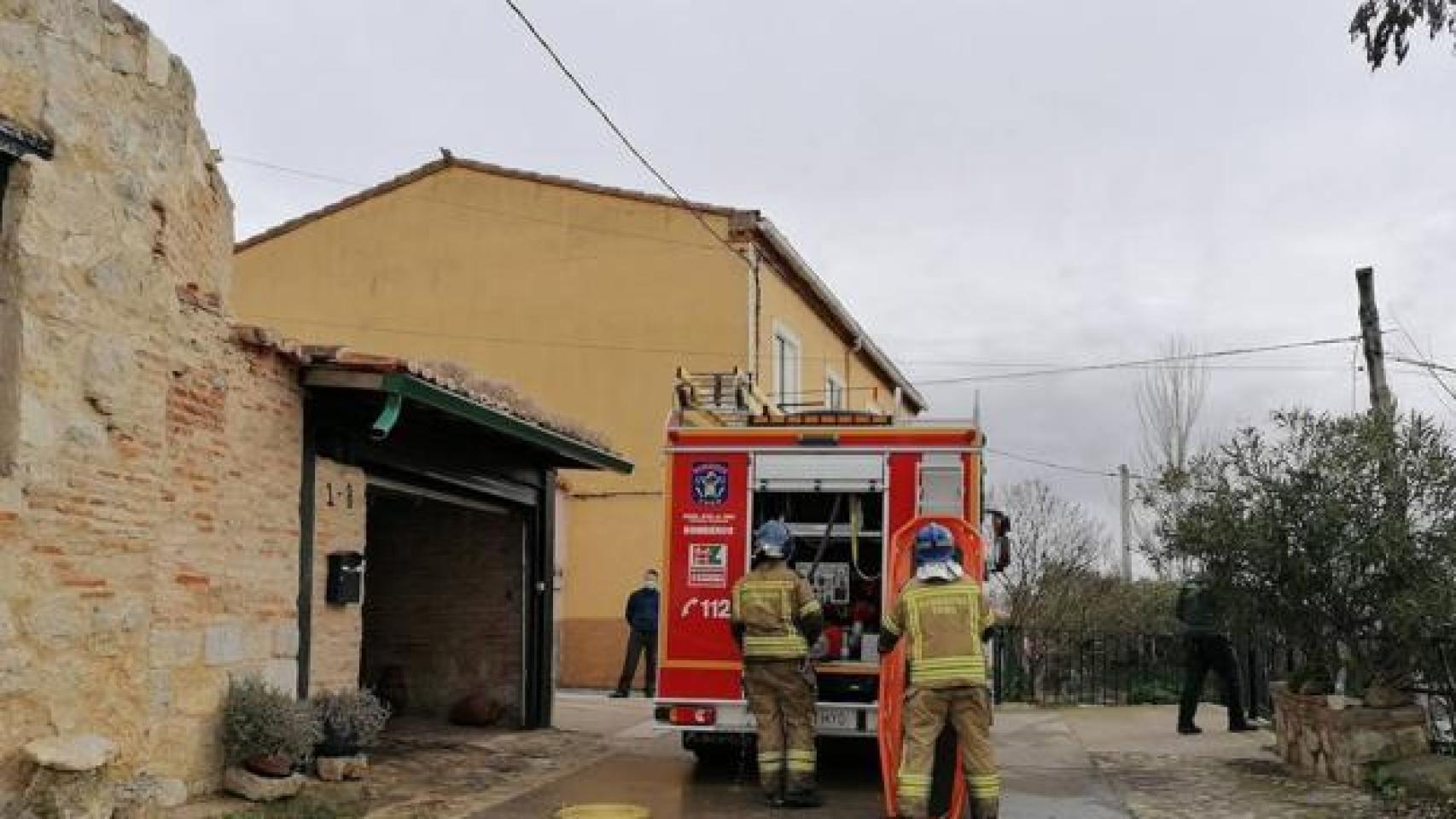 Los bomberos junto a la vivienda donde se ha producido el incendio