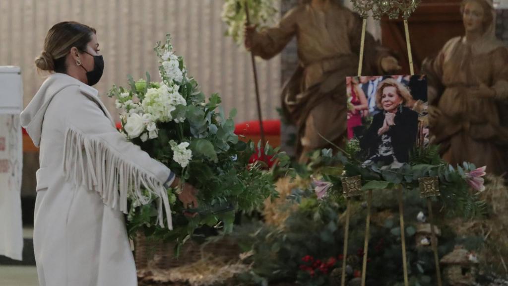 Elena Tablada depositando el ramo de flores en el altar de la capilla.