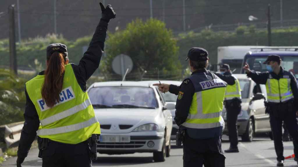 Varios agentes dan el alto a un vehículo en un control por restricciones de movilidad.