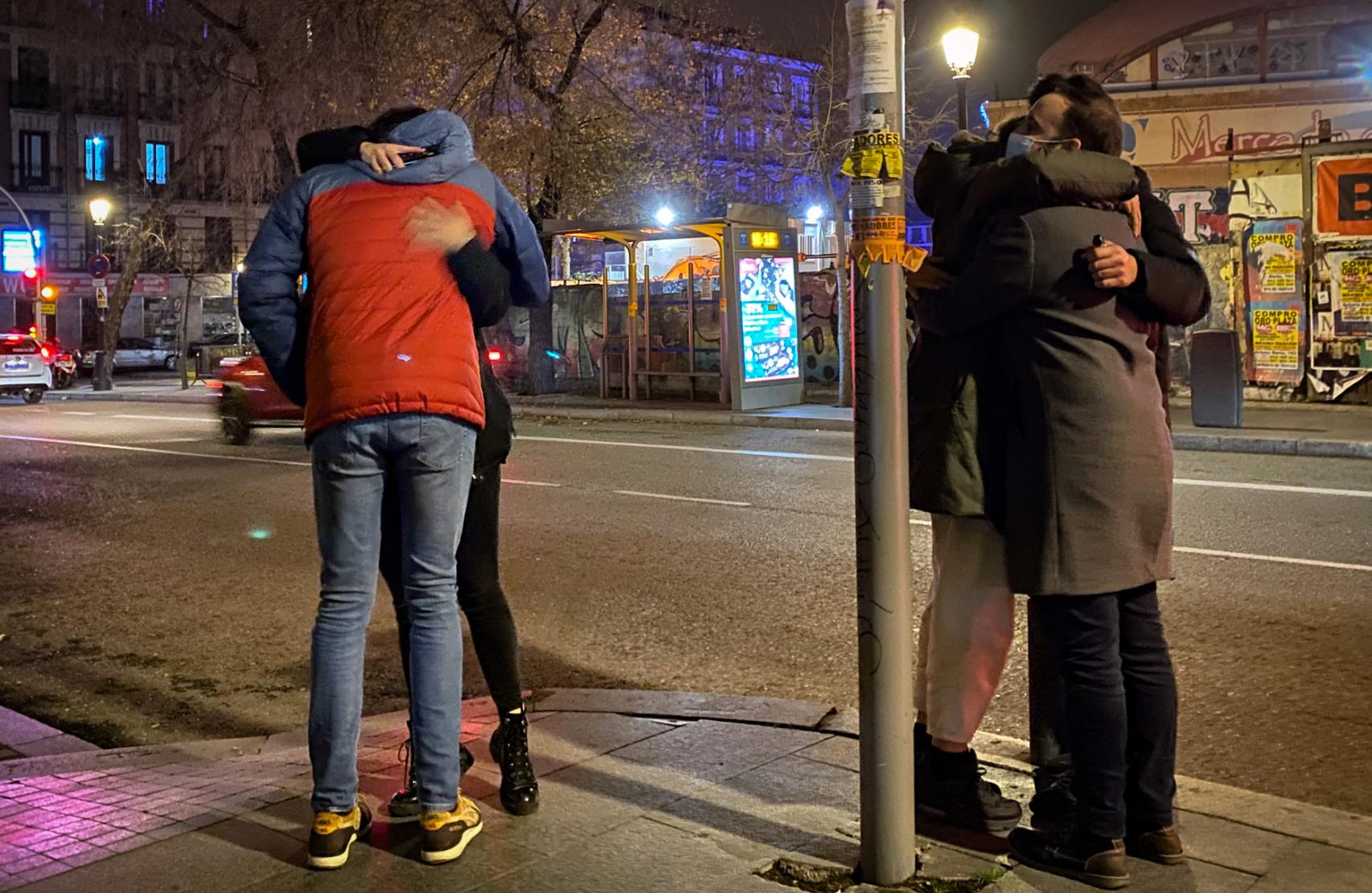 Varios amigos se dan un abrazo al cierre de los bares, la noche de este viernes.