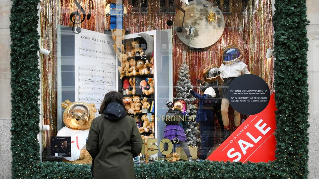 Una persona contempla el escaparate de una tienda de Amsterdam cerrada por la pandemia de Covid.