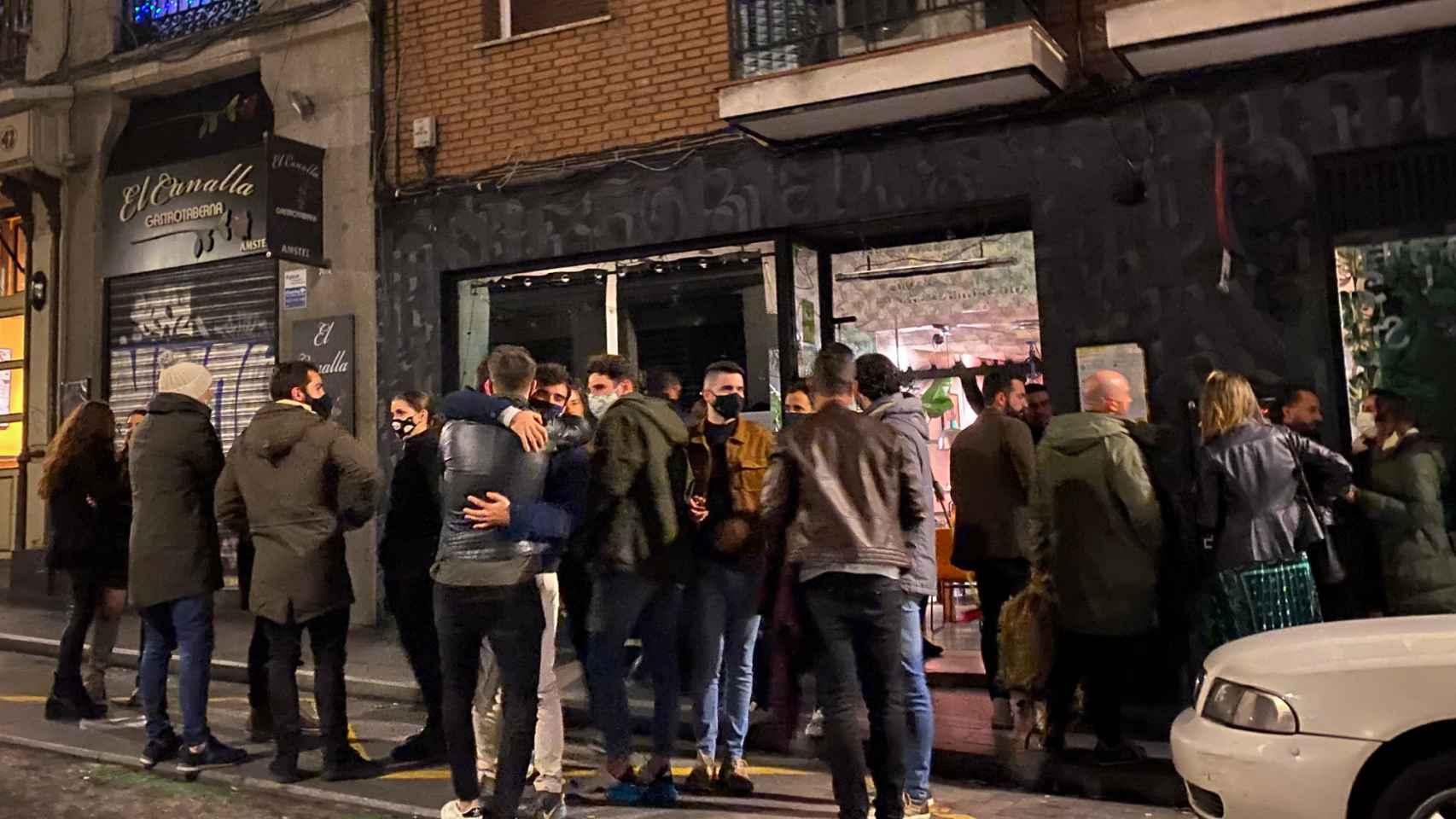 Un grupo de jóvenes se despiden ante el inminente cierre de un bar en el barrio de La Latina, en Madrid.