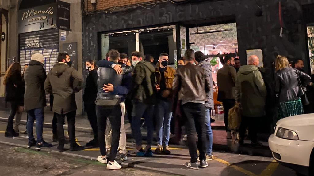 Un grupo de jóvenes se despiden ante el inminente cierre de un bar en el barrio de La Latina, en Madrid.