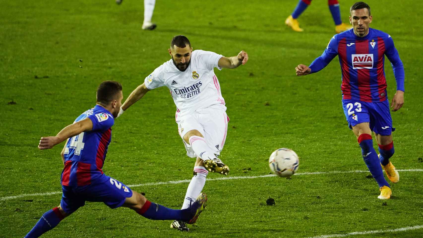 Benzema dispara a la portería del Eibar presionado por dos jugadores rivales