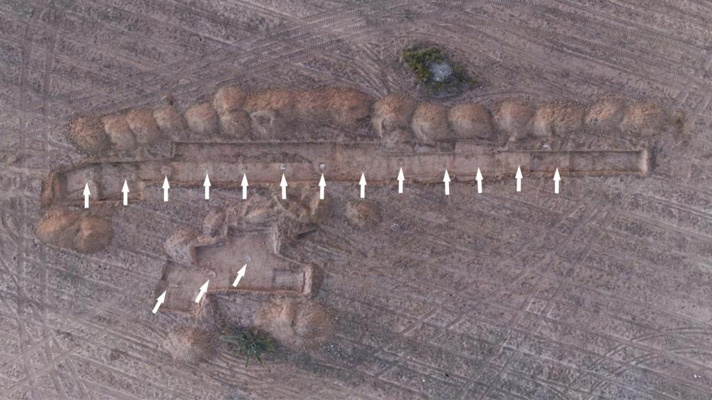 Vista aérea de la zona de sondeos donde se han localizado las estructuras de uno de los barracones. Las cimentaciones de los pilares aparecen marcadas con flechas.