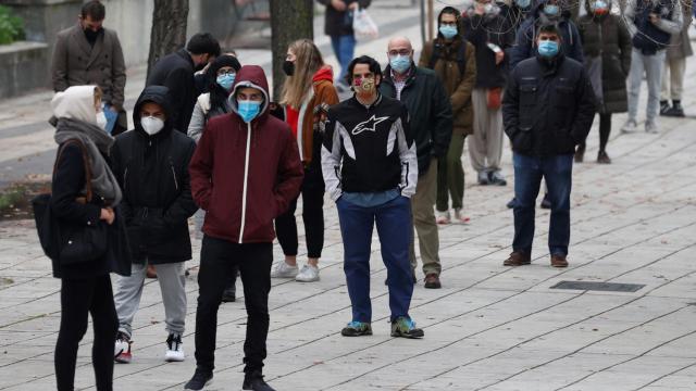 Varias personas hacen cola ante un laboratorio para hacerse una prueba PCR este martes en Madrid, dos días antes de Nochebuena.