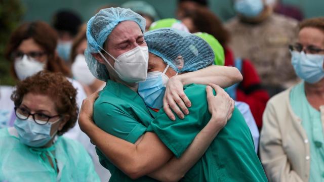 Unos sanitarios se abrazan durante la pandemia.