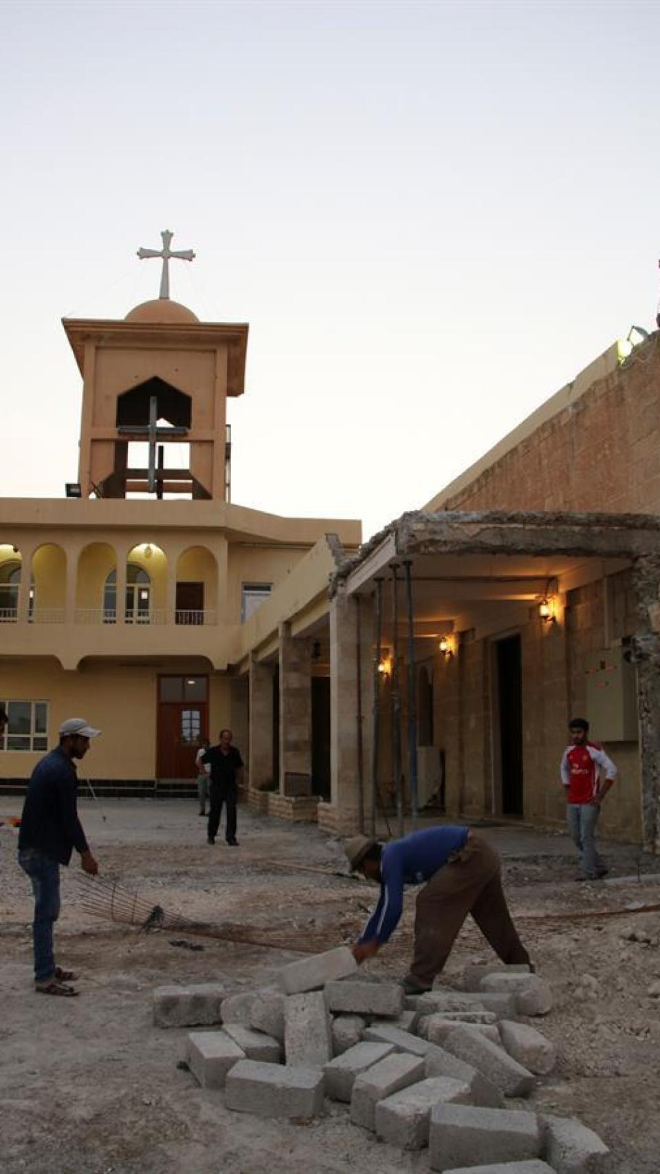 Varios cristianos reconstruyen una de las iglesias destruidas por Estado Islámico en Qaraqosh.