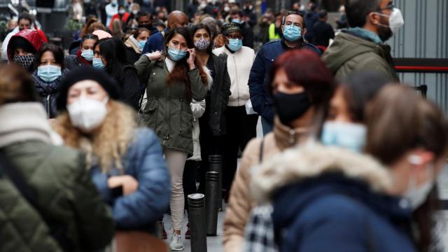 Gente paseando con mascarilla por una calle de Madrid.