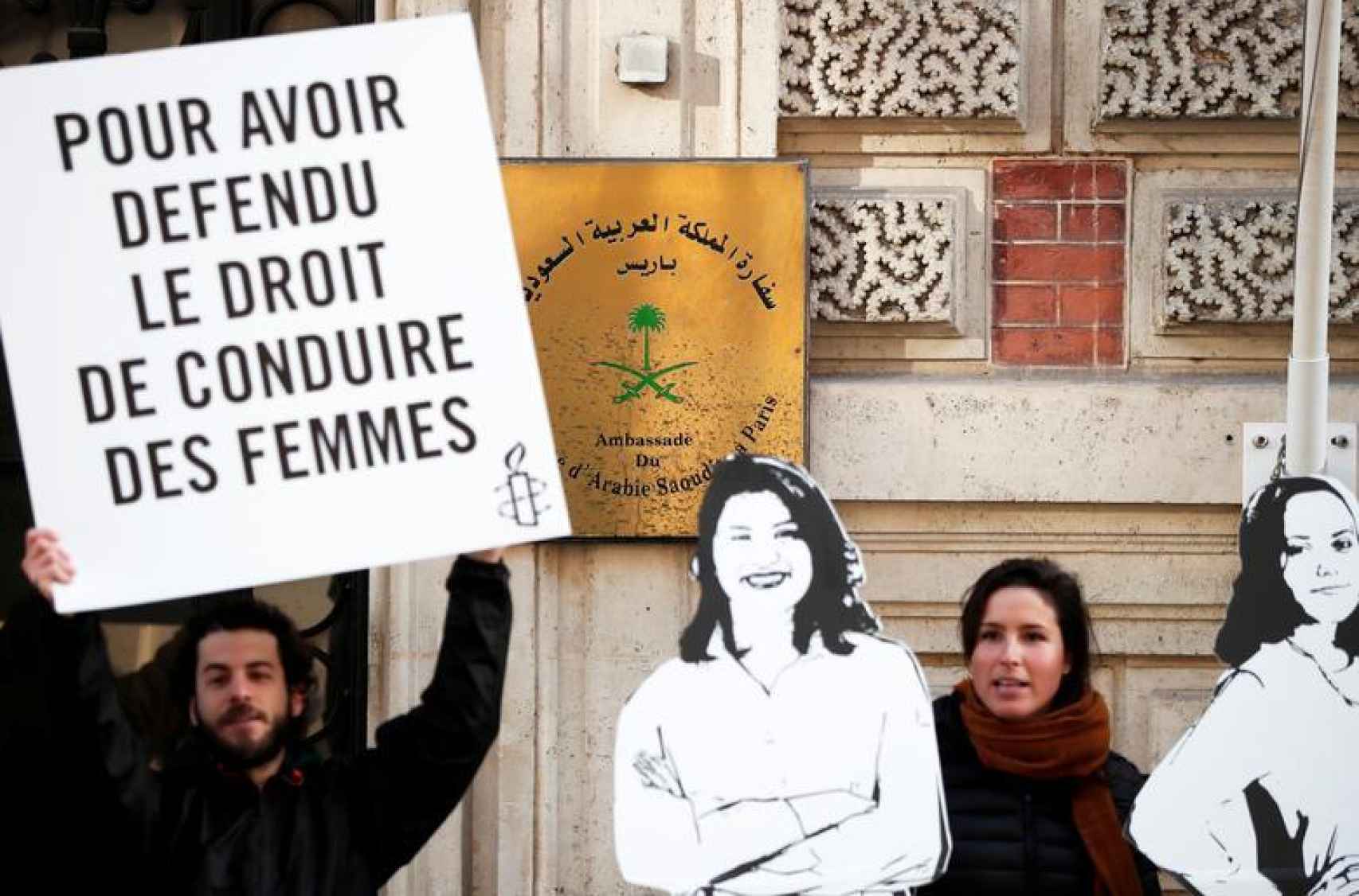 Manifestantes de Amnistía Internacional sostienen pancartas frente a la embajada de Arabia Saudita en París durante el 8-M de 2019 para protestar contra las detenciones de las activistas Loujain al-Hathloul, Eman al-Nafjan y Aziza al-Yousef.
