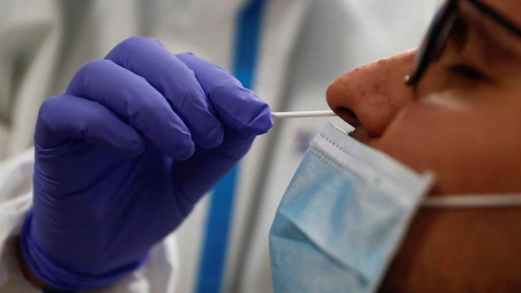 Un sanitario realiza una prueba PCR a un paciente.