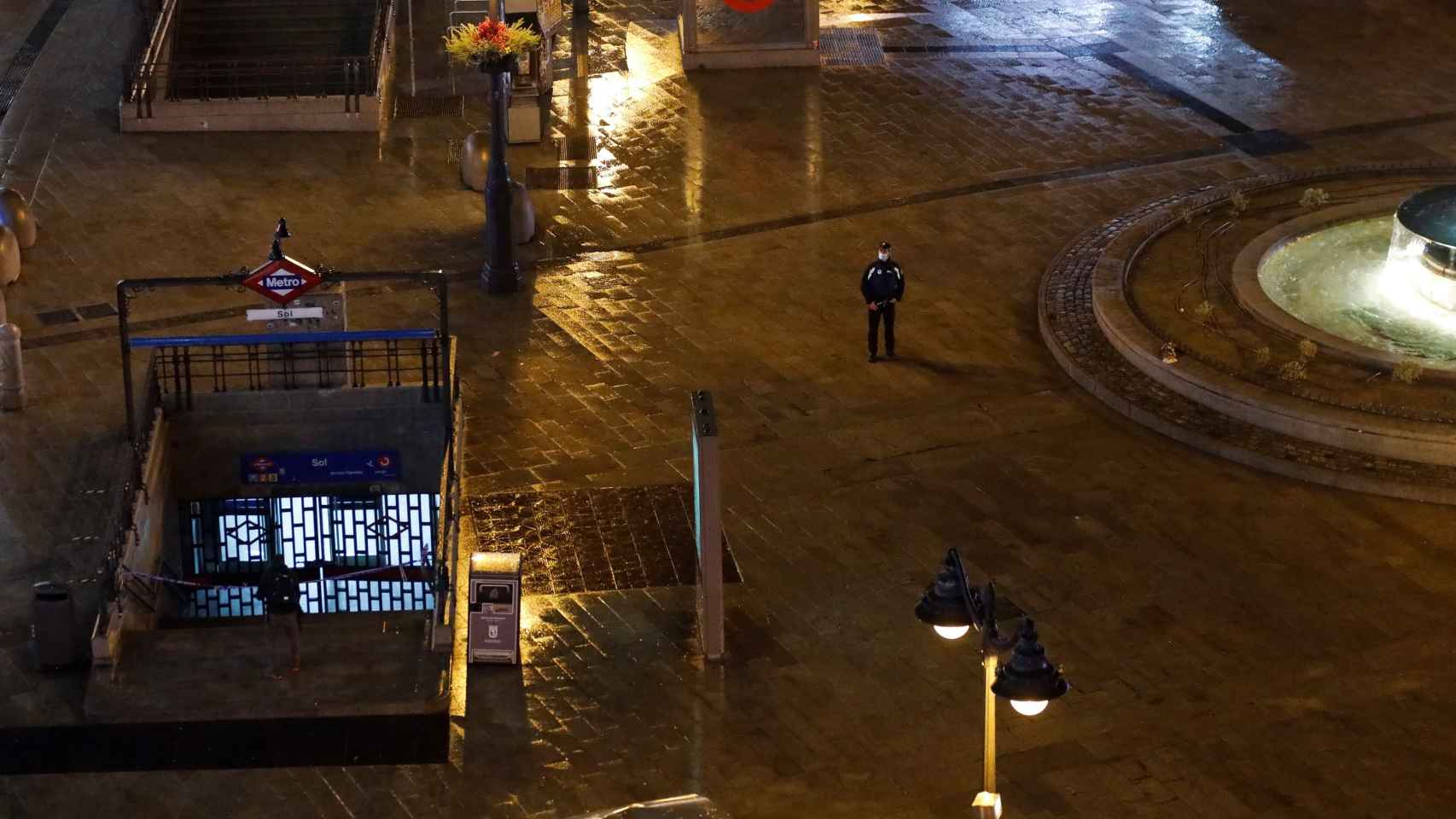 Un policía camina por la Puerta del Sol después del desalojo.