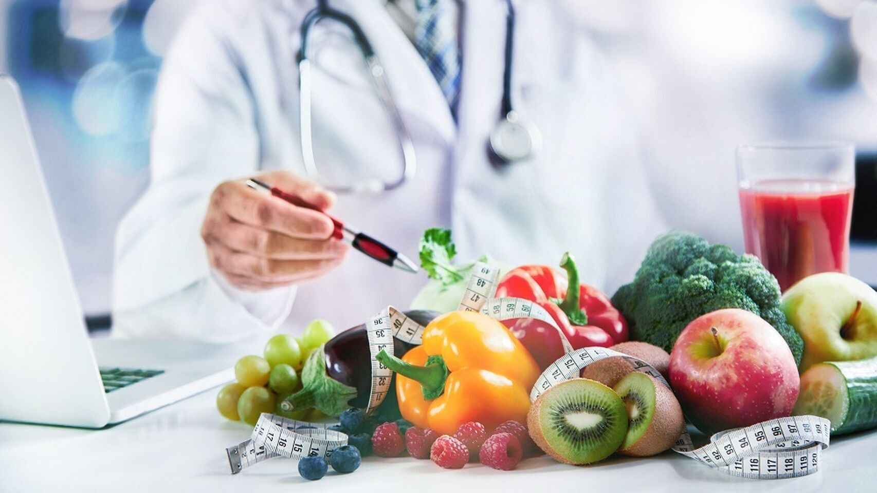 Un médico acompañado de alimentos saludables.