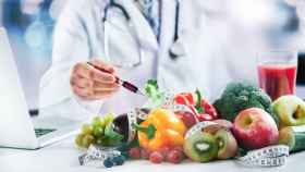 Un médico acompañado de alimentos saludables.