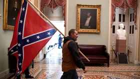 Uno de los asaltante del Capitolio, con una bandera confederada.