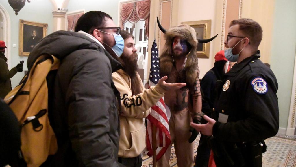 Jake Angeli, en el centro, durante la primera discusión con la policía en el interior del Capitolio.