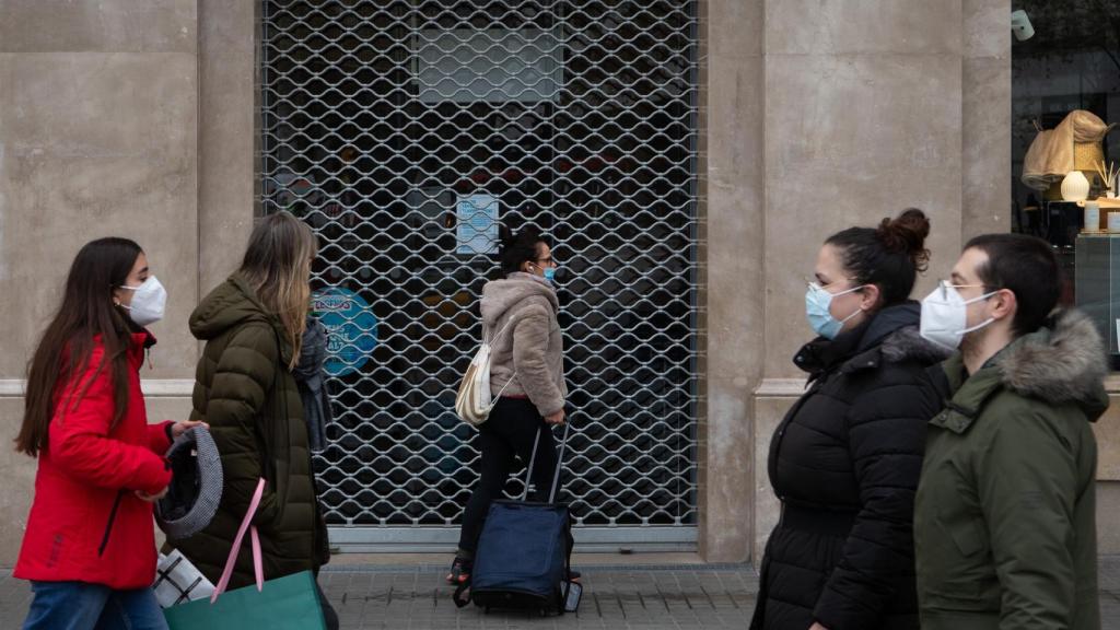 Varios transeúntes pasan ante un comercio del centro de Barcelona.