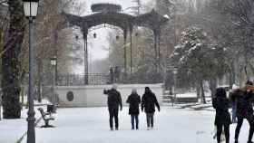 Varias personas caminan este jueves entre la nieve por el Parque Lineal de Albacete.