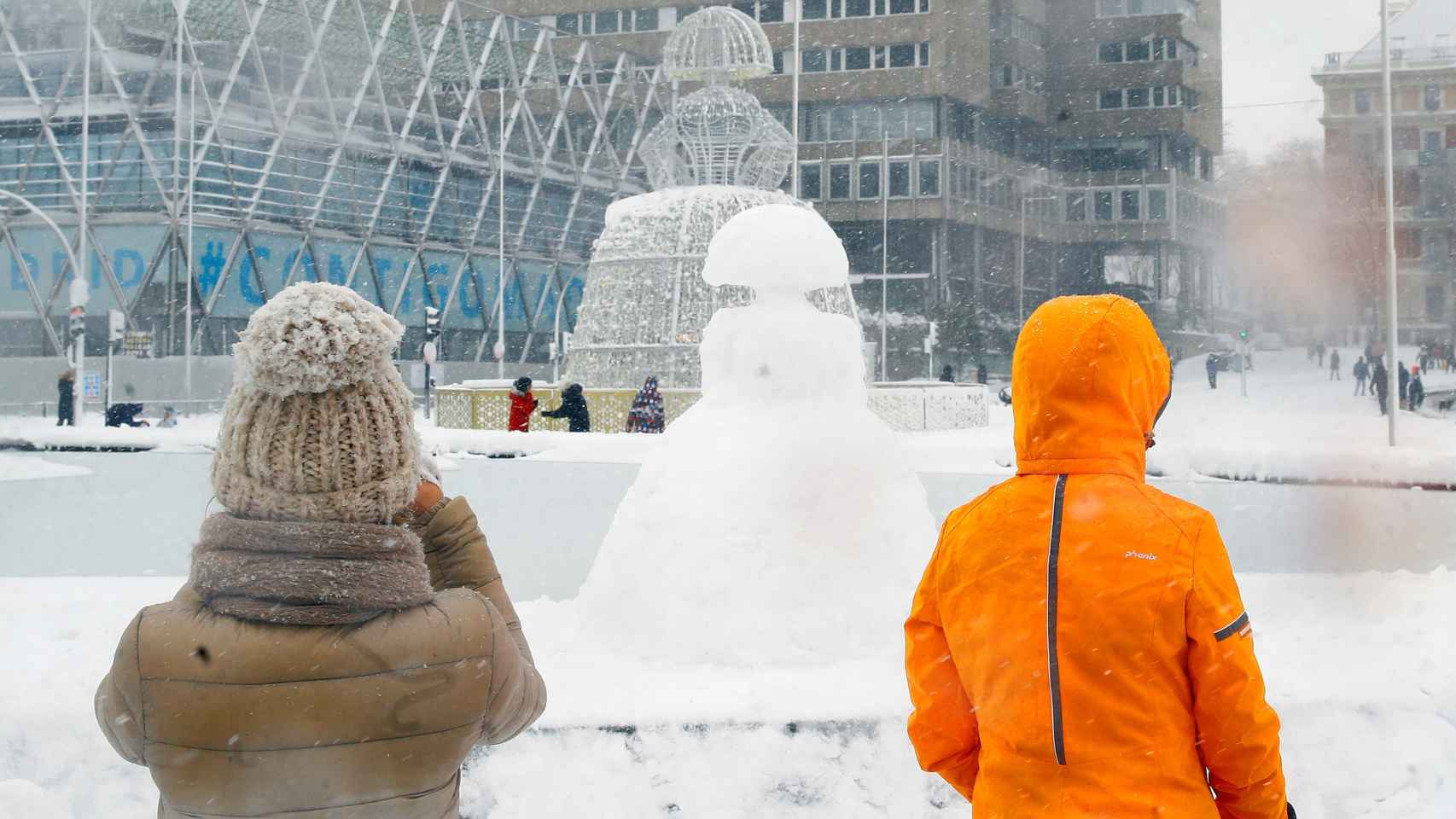 Una estatua de una menina reproducida con nieve en la Plaza de Colón en Madrid cubierta de nieve.