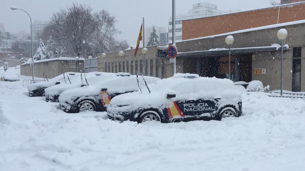 Los coches de la policía, completamente rodeados por la nieve.