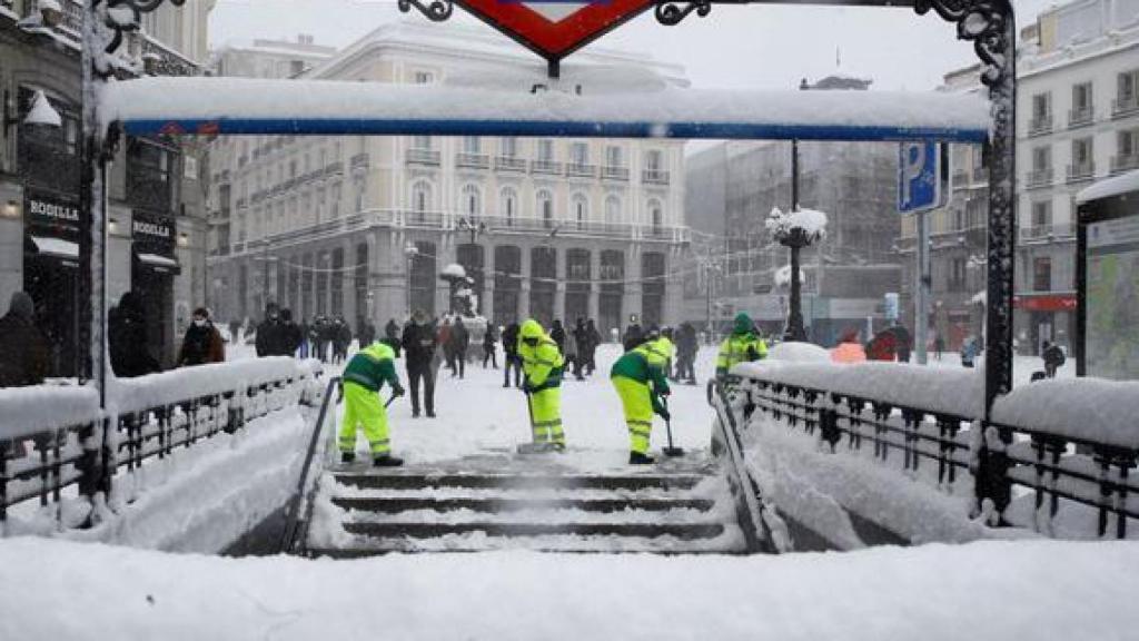 Efectivos quitando nieve en la puerta de la estación de metro de Callao, Madrid