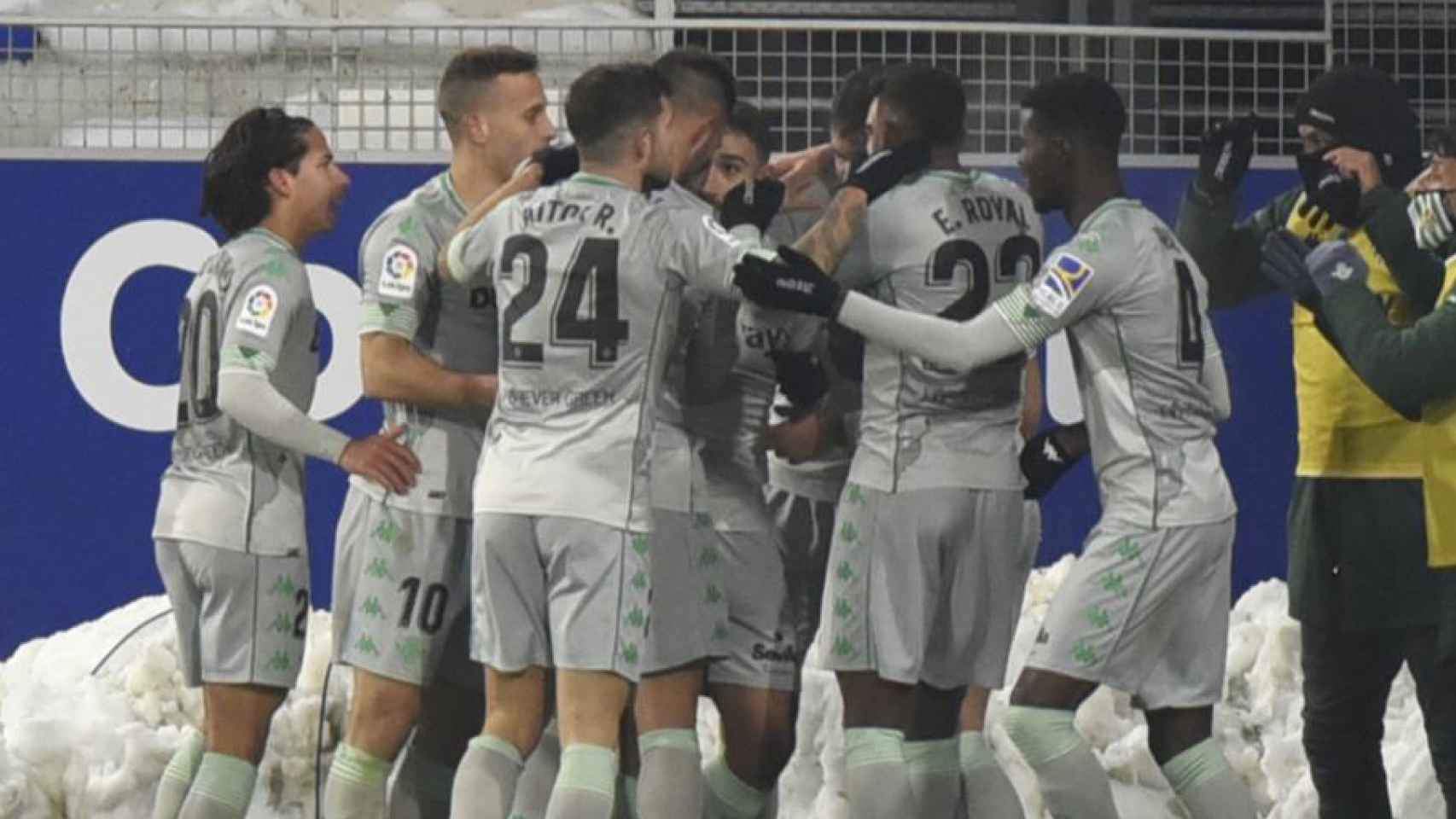 Piña de los jugadores del Betis para celebrar un gol ante el Huesca en la jornada 18 de La Liga
