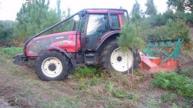 Un tractor desbroza en una finca en Galicia.