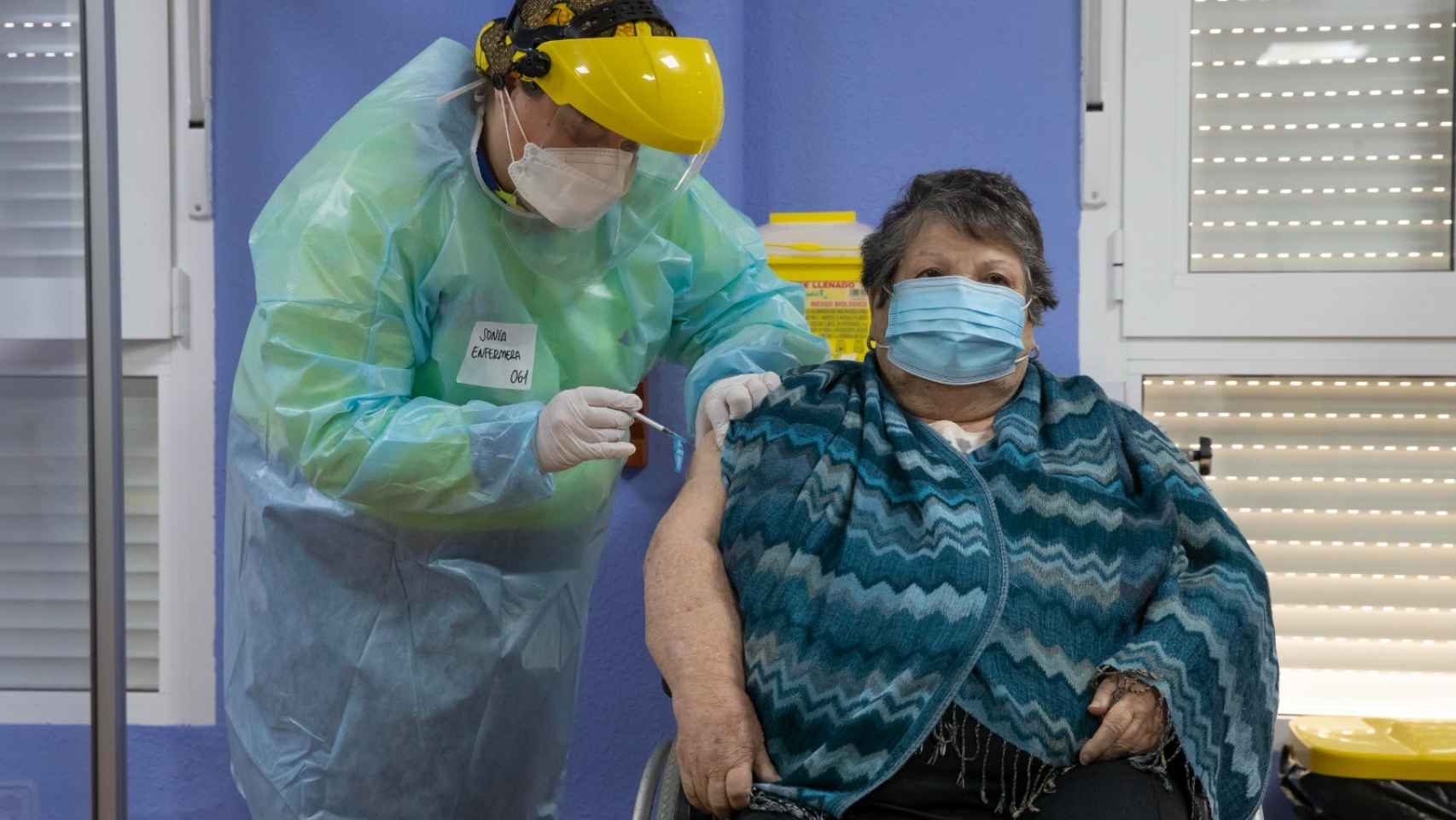 Un sanitario vacunando en una residencia de mayores.