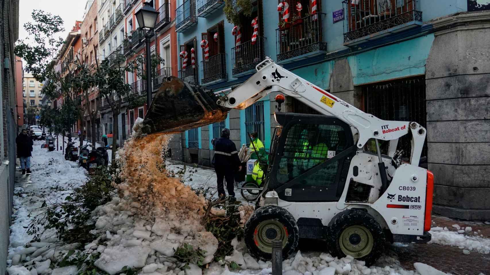 Una excavadora retira nieve de una calle de Madrid.